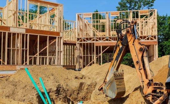 Unfinished house of still under construction. Building concept The excavator digs new building